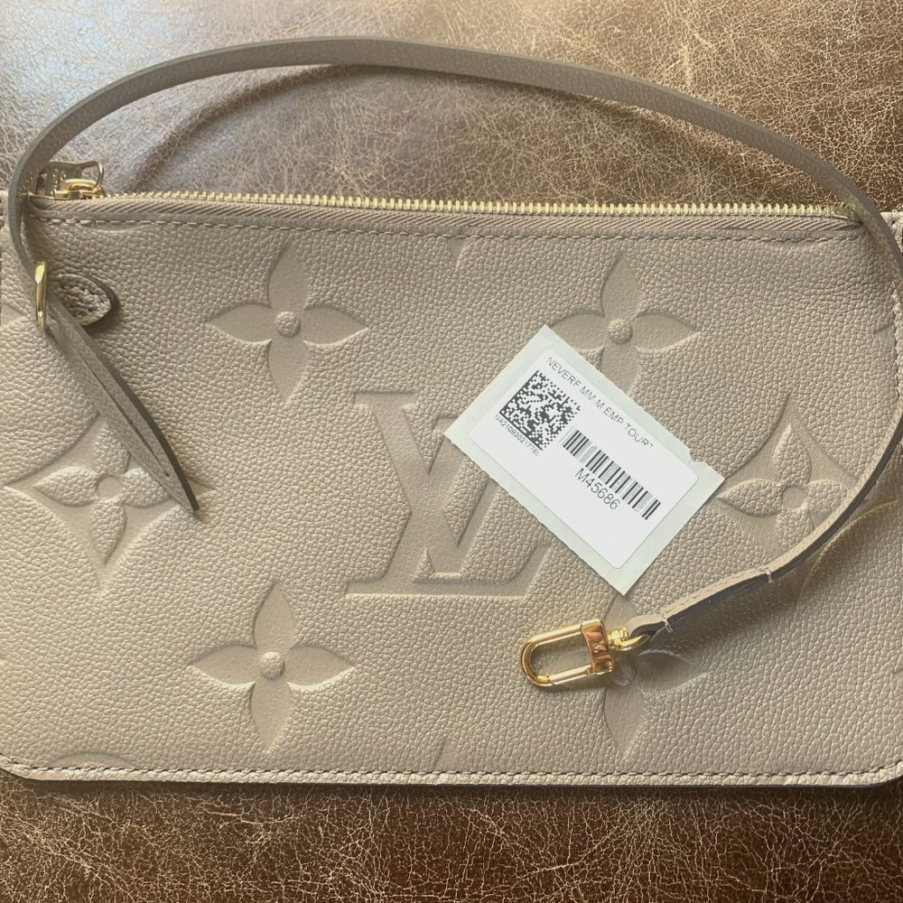 Louis Vuitton Never full mm wristlet Monogram Empreinte Leather In Turtle Dove.